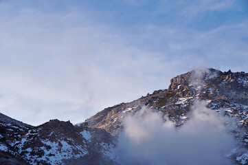 Fototapeta na wymiar 水蒸気を上げる岩山。