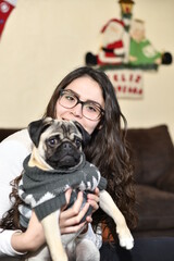 Adorable Pug, pulls the hair of a young woman