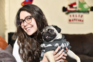 Adorable Pug, pulls the hair of a young woman