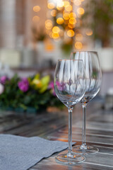 Modern veranda restaurant interior, flowers, banquet setting, glasses, plates