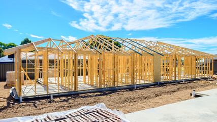 New Australian house timber frame installation process at a construction site on a bright summer day © myphotobank.com.au