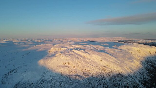 Sunrise over snow covered mountains in Southern Norway. Zooming in drone footage