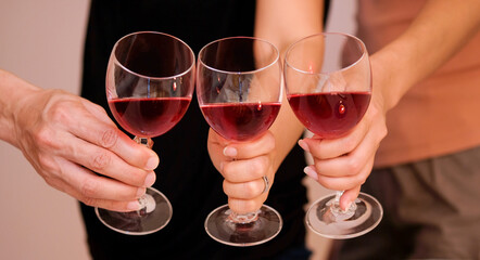 Hand of celebrate successfully with red wine in the party. Young toasting in party and drinking after work hard for relax and be enjoy. Celebration Concept , Cheers!