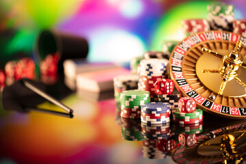 Fototapeta na wymiar Casino theme. Gambling games. Roulette, dice and poker chips on a colorful bokeh background.