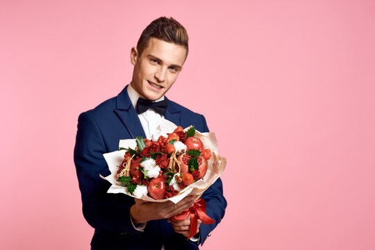 man in a suit bouquet of flowers romance date pink background