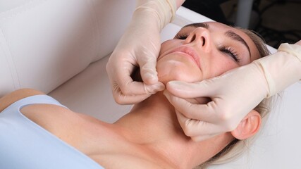 Fototapeta na wymiar Chin massage of woman young woman during face massage at beauty salon