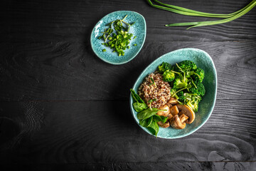 Diet salad made from fresh vegetables broccoli, mushrooms, spinach and quinoa in a bowl. Delicious breakfast or snack, Clean eating, dieting, vegan food concept. vertical image