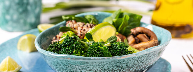 Healthy food. Fresh green salad with quinoa, spinach, broccoli, mushrooms and microgreens on light background, top view