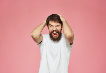 An energetic man on a pink background gestures with his hands