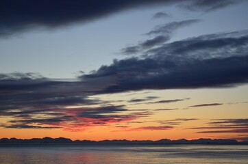 Fototapeta premium majestic colorful sunset over fjord and mountain landscape with sea fog on the island of Senja, Northern Norway