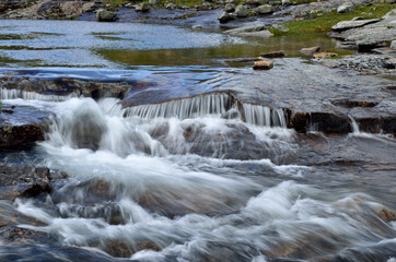 calm mountain lake with serene creek and waterfall