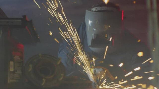 Man wearing a helmet with sparks flying around him