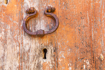 Italy, Sicily, Province of Messina, Novara di Sicilia. A rusted door ring on a weathered door in the medieval hill town of Novara di Sicilia.