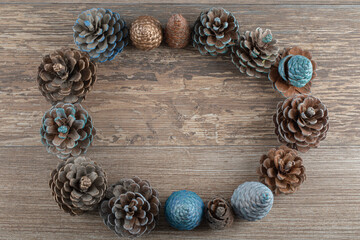 Natural blue and golden colored oak tree cones on a wooden deck