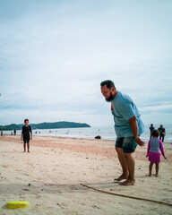 Happy family of four playing with the disc at the beach. Family, kids and nature concept.