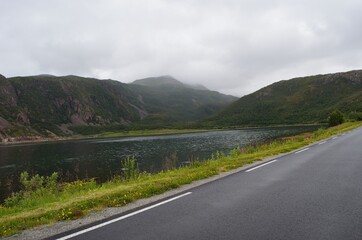 road in the mountains with fjord and clouds
