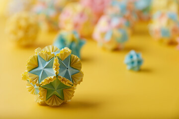 Set of multicolor handmade modular origami balls or Kusudama Isolated on yellow background. Visual...
