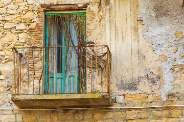 Fototapeta na wymiar Italy, Sicily, Enna Province, Centuripe. A rusted balcony on a rustic building in the hill town of Centuripe.