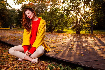 A girl is relaxing in an evening autumn park.