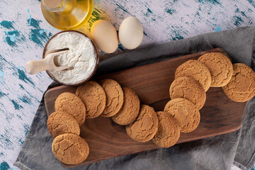 Fototapeta na wymiar Oatmeal cookies in a wooden platter with ingredients around