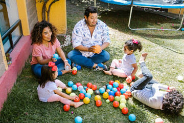 mexican parents with children playing at backyard in home in Mexico city