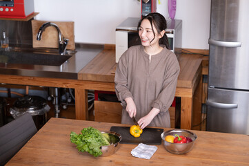 話しかけられて振り返るキッチンで料理をする美しい日本人女性...