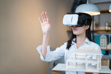 Asian woman architect simulate house design with virtual headset goggle at home office
