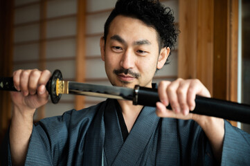 骨董品の鑑定をしている日本人男性 © kapinon