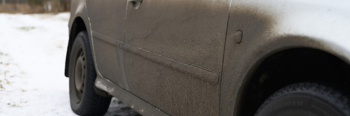 very dirty gray car in the autumn or winter in the mud. banner