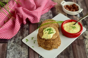 Vegan pinto bean patties with vegan mayo mustard sauce garnish with chives