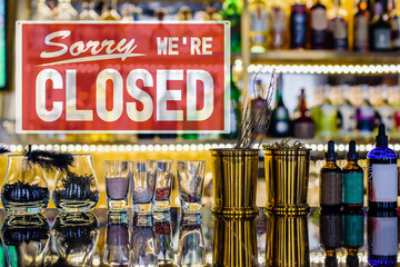 Informational board on bar background with text Sorry, we're closed