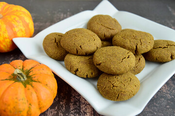 Pumpkin cookies on wooden background with pumpkins on the side