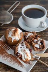 Sweet cherry muffin with ice cream and white cup with tea on a wooden background