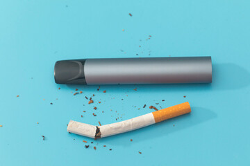 Electronic cigarettes and tobacco on  blue background.  Quit smoking.