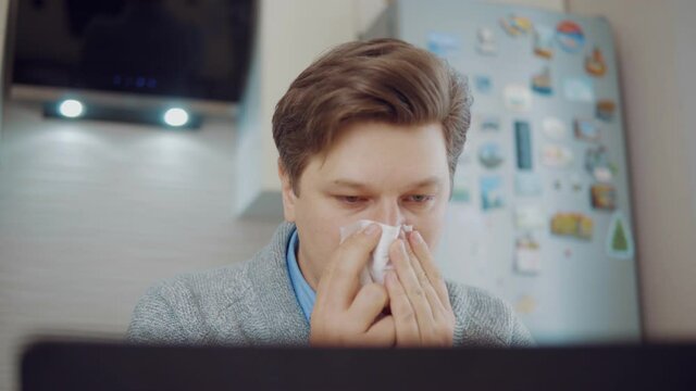 Runny nose. Young man having nose problems