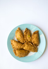 Gujeeya - an authentic Indian sweet arranged on a modern plate. View from above.