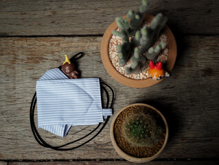 Top view of Stack cotton, white tissue paper and DIY fabric cotton face mask on wood table. Protect...