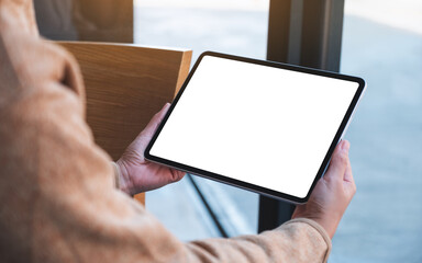 Mockup image of a woman holding digital tablet with blank white desktop screen