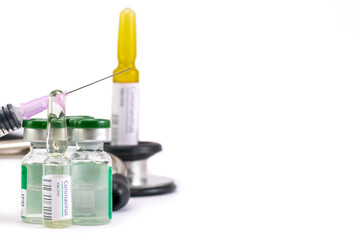 Corona Virus Vaccination ampoules with an injection needle, vials and stethoscope.