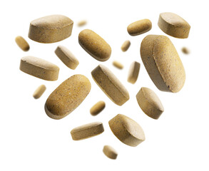 Yellow tablets in the shape of a heart on a white background