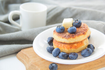 A healthy breakfast of pancakes, berries, butter, and honey