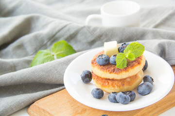 A healthy breakfast of pancakes, berries, butter, and honey