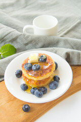 A healthy breakfast of pancakes, berries, butter, and honey