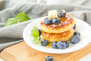 A healthy breakfast of pancakes, berries, butter, and honey