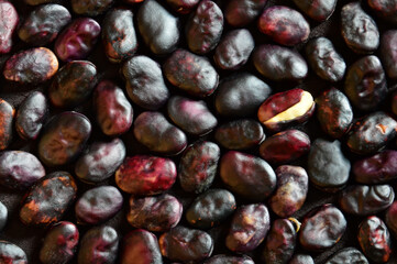 Ripe beans closeup background. One bean has a cracked skin
