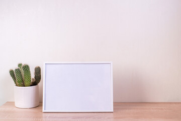 Portrait white picture frame mockup on wooden table. Modern ceramic vase with gypsophila. White wall background. Scandinavian interior.