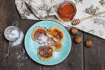 Plate with apple fritters on rustic wooden table.