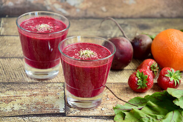 Healthy smoothie made from beetroot, strawberry, orange, beetroot leaves and hemp seeds