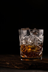 whiskey or cognac with ice in a glass, close up