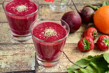 Healthy smoothie made from beetroot, strawberry, orange, beetroot leaves and hemp seeds